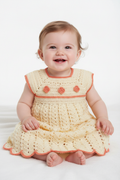 Bebé com vestido de crochet creme e detalhes salmão